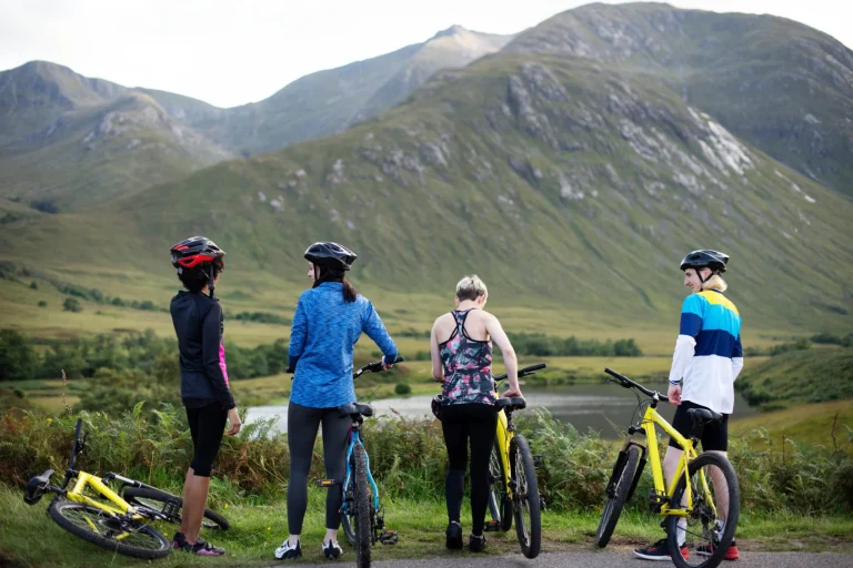 Group of cyclists by the riverside in the Highlands